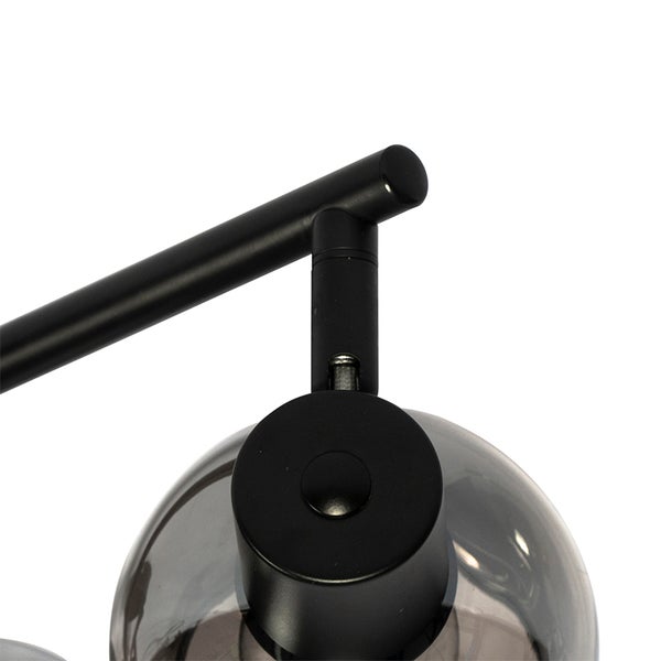 Detailansicht einer schwarzen Lampe mit Rauchglas-Lampenschirm