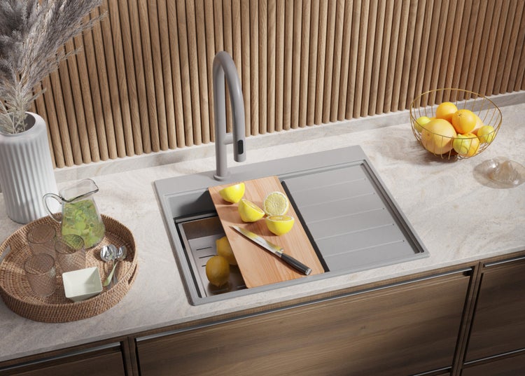 Küchenspüle mit Armatur, Schneidebrett und Zitronen auf einer Arbeitsplatte