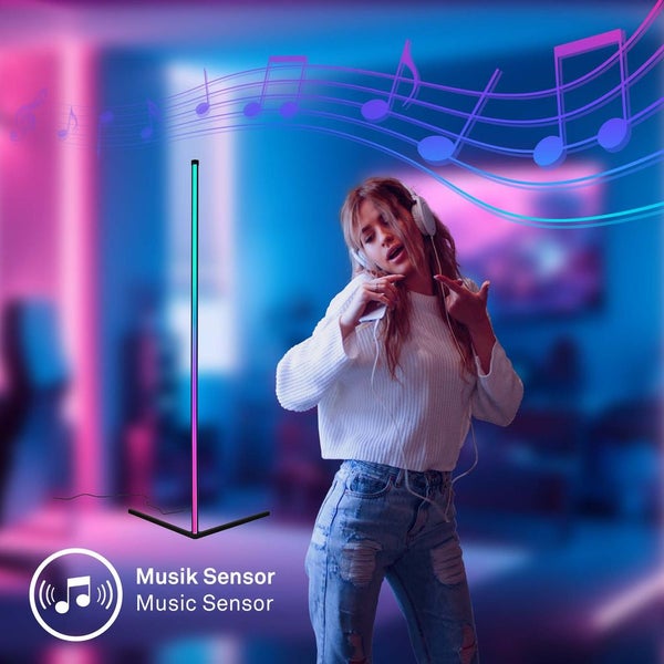Moderne LED Stehleuchte mit Musik Sensor, schlankes Design, mehrfarbig leuchtend neben einer tanzenden Person mit Kopfhörern.