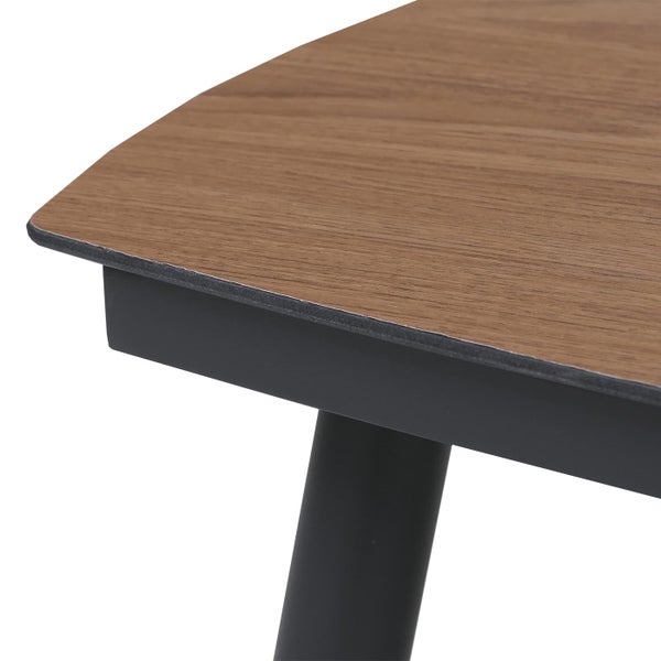 Nahaufnahme einer Tischecke mit einer Tischplatte in Holzoptik und einem schwarzen Metallgestell.