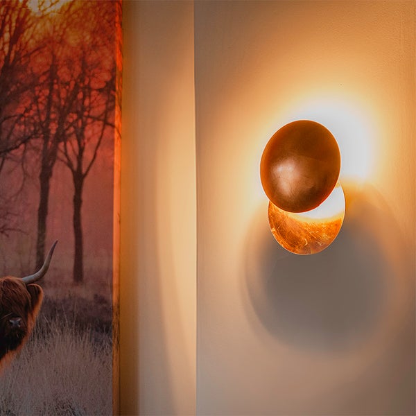 Wandleuchte mit zwei kreisförmigen Elementen zur Beleuchtung von Innenräumen.
