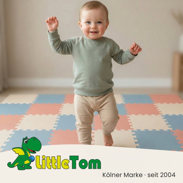Kleinkind steht auf einer bunten Puzzle-Spielmatte aus Schaumstoff in einem hellen Raum. LittleTom Logo.