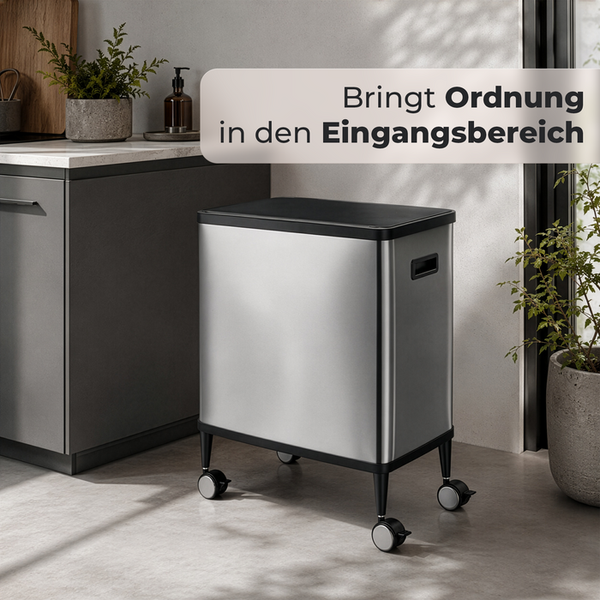 Mobiler Aufbewahrungsbehälter aus Edelstahl mit Rollen und schwarzem Deckel im modernen Eingangsbereich.