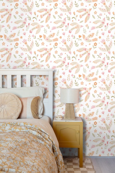 Schlafzimmer mit Bett und Nachttisch vor einer Tapete mit Vogel- und Blumenmuster.