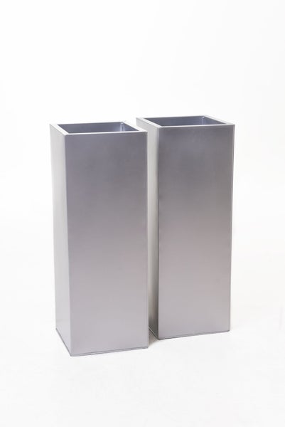 Zwei hohe, quadratische Pflanzsäulen aus silberfarbenem Metall.