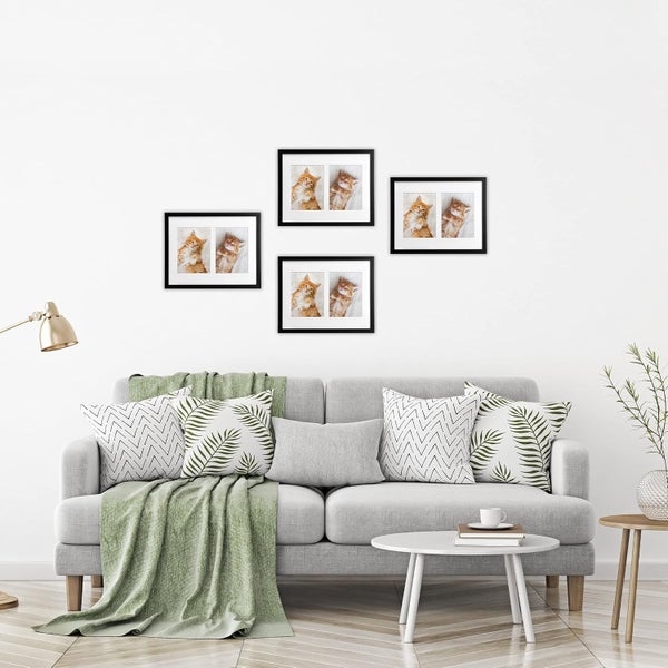 Wohnzimmer mit grauem Sofa, Kissen, Überwurf und vier schwarzen Bilderrahmen mit Katzenbildern an der Wand