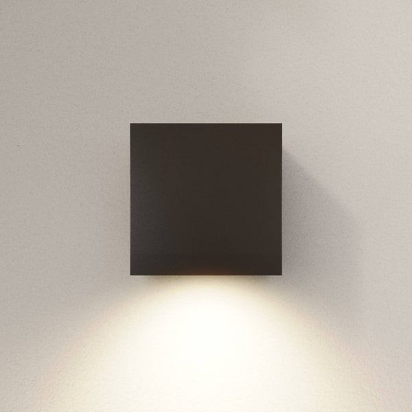 Quadratische schwarze Wandleuchte mit Lichtaustritt nach unten.
