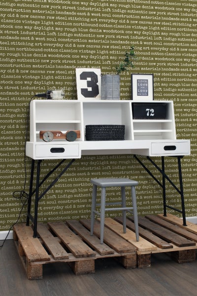 Dekoratives Arbeitszimmer mit weißem Schreibtisch, grauem Stuhl und Holzpalette