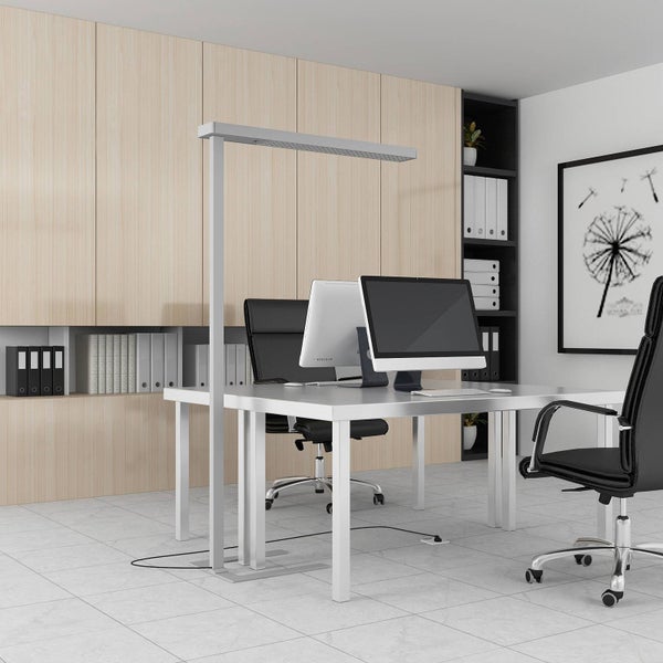 Moderne LED-Büro-Stehleuchte an einem hellen Doppelarbeitsplatz mit Schreibtischen, Monitoren und Bürostühlen in einem organisierten Büro.