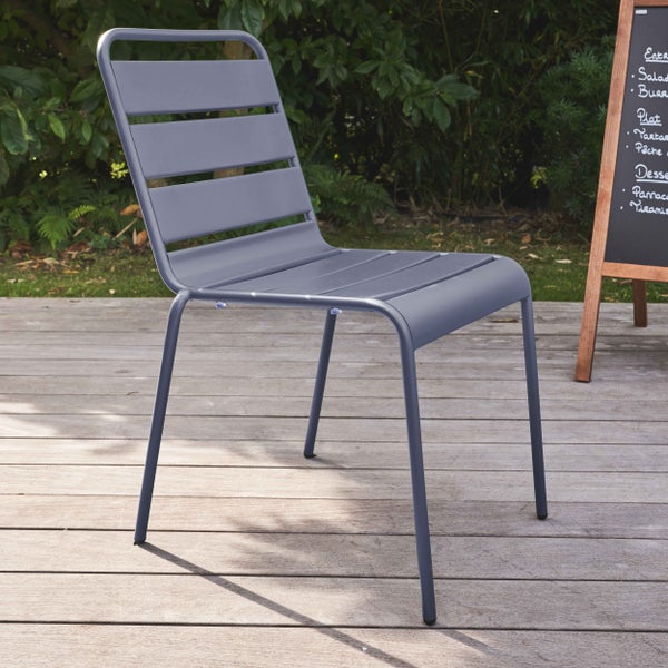 Grauer Gartenstuhl aus Metall mit Sitzfläche und Rückenlehne aus Latten auf einer Holzterrasse.