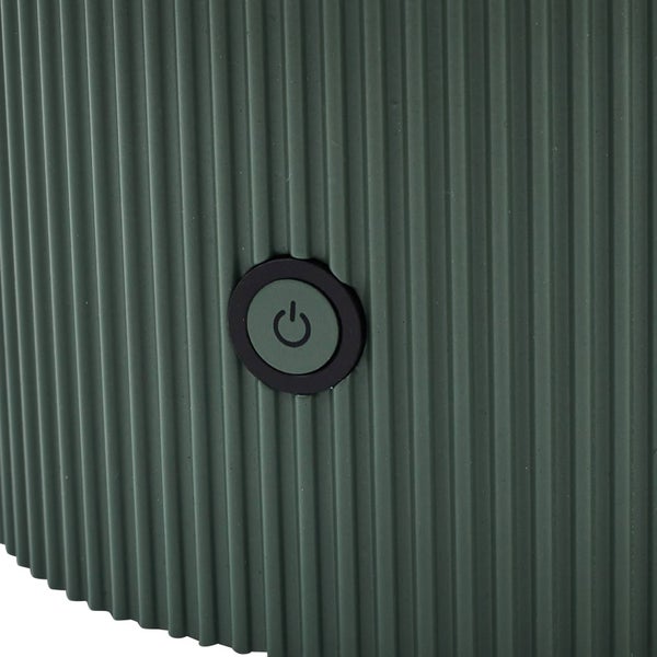 Nahaufnahme eines runden Ein- und Ausschalters auf einer gerippten, grünen Oberfläche.