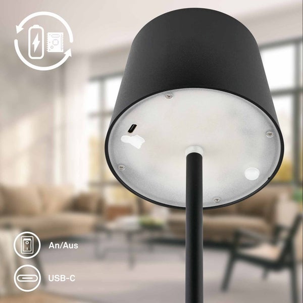 Detailansicht einer schwarzen Akkuleuchte in einem hellen Wohnzimmer mit USB-C Anschluss und Ein- und Ausschalter unter dem Lampenschirm.
