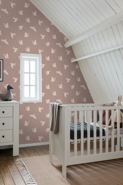 Babyzimmer mit Kinderbett, Kommode und Tapete mit Vogelmuster