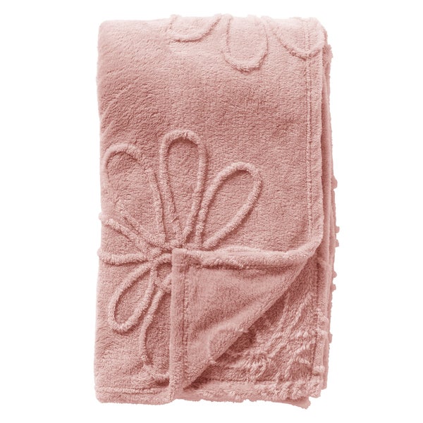 Weiche, rosa Wohndecke mit eingeprägtem Blumenmuster, zusammengefaltet.
