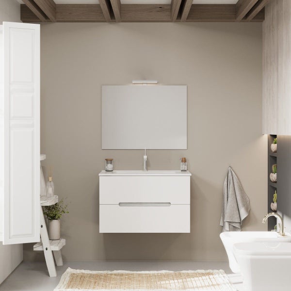 Modernes Badezimmer mit weißem Waschbeckenunterschrank, rechteckigem Wandspiegel mit Leuchte und hängender Sanitärkeramik vor einer beigen Wand.