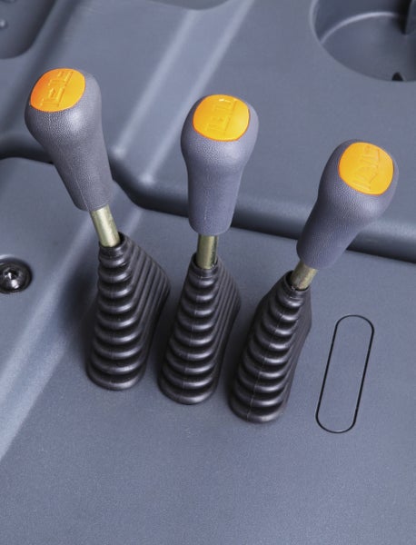 Drei Bedienhebel mit strukturierten Griffen, Faltenbalg und Symbolkappen auf einer Konsole.