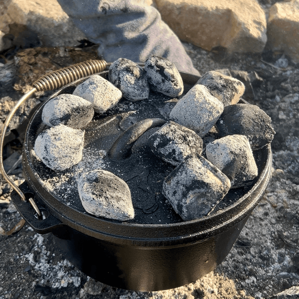 Gusseiserner Topf mit Grillkohle