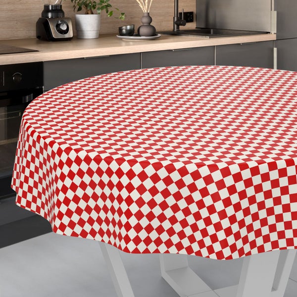 Runde Tischdecke mit rot-weißem Karomuster auf einem runden Tisch in einer modernen, hellen Küche.