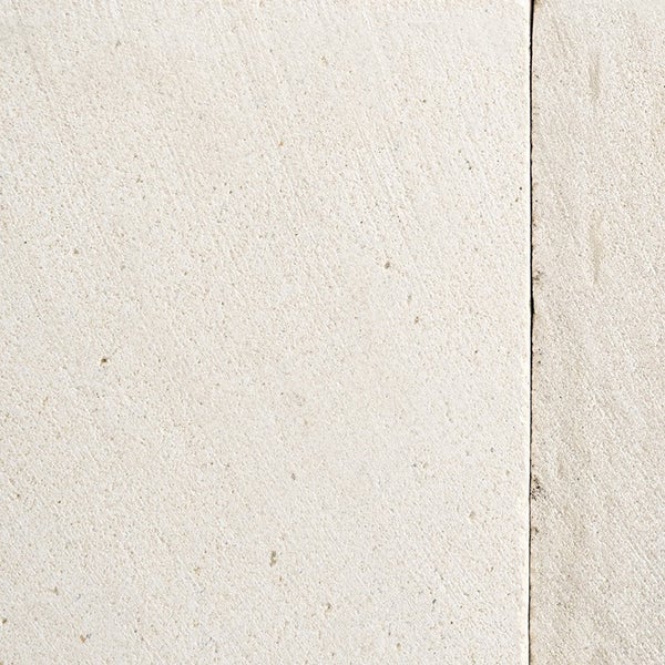 Oberfläche einer hellen Natursteinplatte mit feinkörniger Textur und gerader Fuge