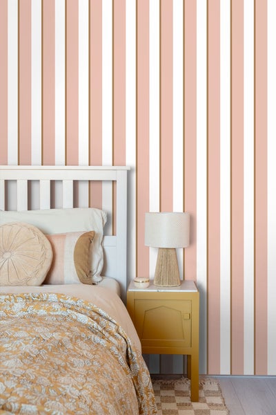 Schlafzimmer mit Bett, Nachttisch und gestreifter Tapete