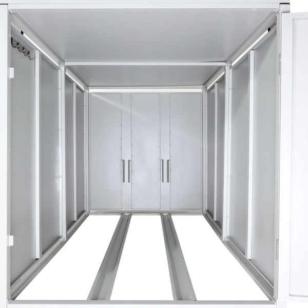 Innenansicht eines leeren Metallgerätehauses mit Bodenprofilen und Kleiderhaken an der Seitenwand.