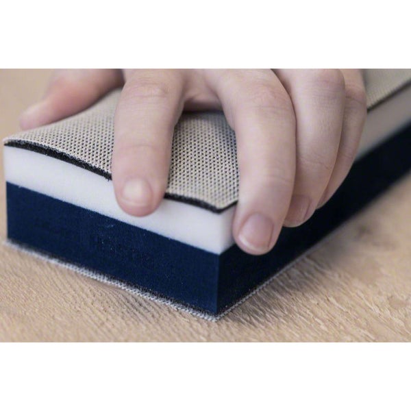 Schleifklotz mit Hand auf Holzgrund