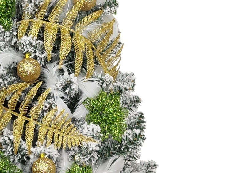Künstlicher Weihnachtsbaum mit Schneeoptik, geschmückt mit glitzernden Farnwedeln, Kugeln und Federn als weihnachtliche Dekoration.