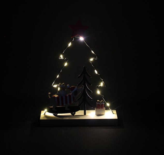 Beleuchtete Weihnachtsdekoration aus Holz in Form eines Weihnachtsbaums mit einem Hund auf einem Skateboard und Geschenken.