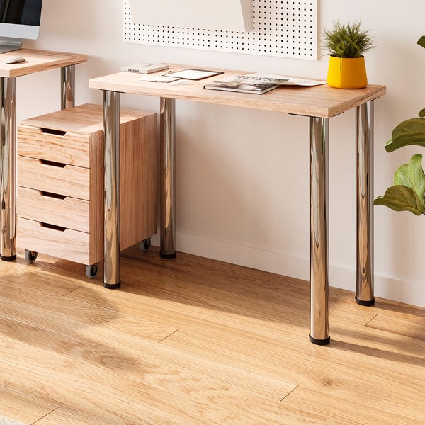 Schreibtisch aus Holz mit runden Metallbeinen und passendem Rollcontainer in einem modernen Arbeitszimmer mit Lochwand.