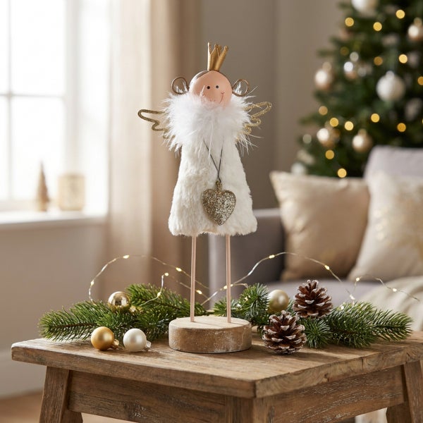 Dekorative Weihnachtsengel Figur mit Stoffkleid und Herzanhänger auf einem Holzsockel als Tischdekoration.