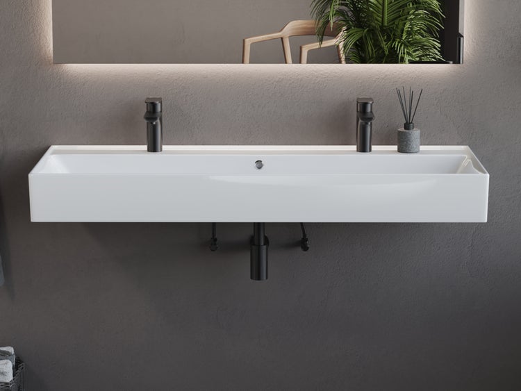 Waschtisch mit zwei Armaturen und beleuchtetem Spiegel