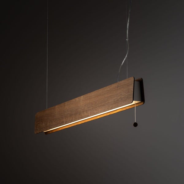 Moderne LED-Pendelleuchte aus dunklem Holz in länglicher Form mit Seilzugschalter und dünner Drahtaufhängung.