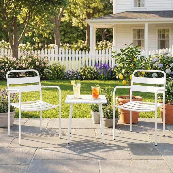 Modernes weißes Gartenmöbel-Set mit zwei Metallstühlen und einem Beistelltisch auf einer Steinterrasse in einem hellen, sonnigen Garten.