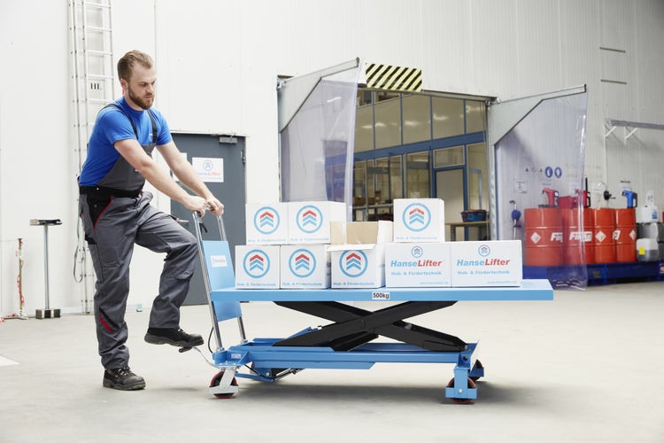Mitarbeiter bedient einen blauen Scherenhubwagen von HanseLifter in einer hellen Lagerhalle, beladen mit Paketen auf einer Metallplattform.