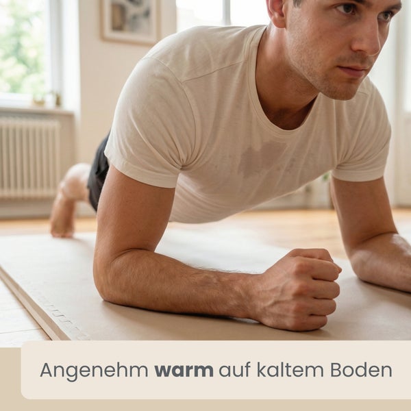 Ein Mann macht eine Plank-Übung auf einer wärmeisolierenden Fitnessmatte auf Holzboden.