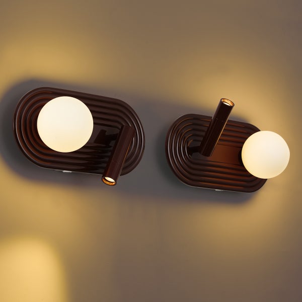 Zwei moderne Wandleuchten mit ovalem Grundkörper, Kugelglas und zusätzlichem Spot.