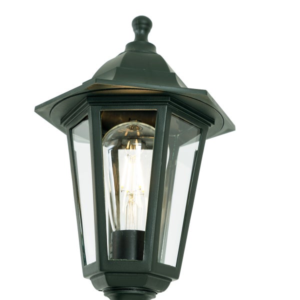 Klassische sechseckige Außenleuchte mit dunklem Metallgestell, Klarglasscheiben und leuchtendem LED Filament Leuchtmittel.