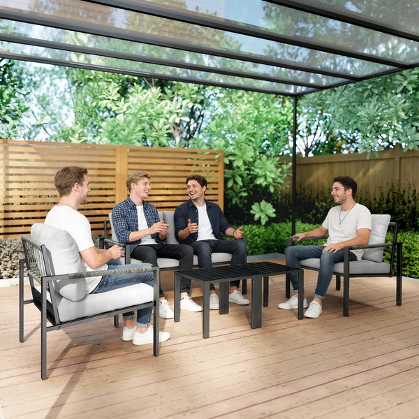 Modernes Garten-Lounge-Set mit Sofa, zwei Sesseln, grauen Kissen und zwei Tischen auf einer Holzterrasse unter einer Terrassenüberdachung.