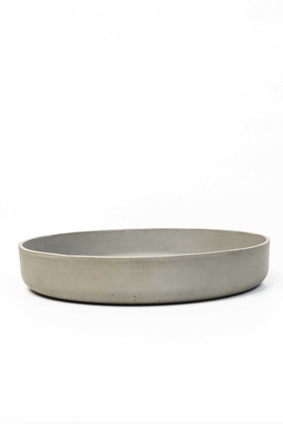 Runder Pflanzenuntersetzer aus Beton, flache Form mit niedrigem Rand.