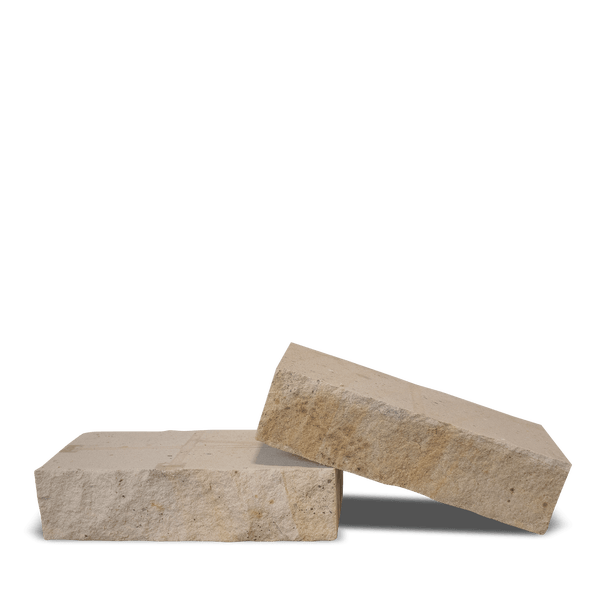 Zwei Mauersteine aus beigem Naturstein mit bruchrauer Oberfläche.