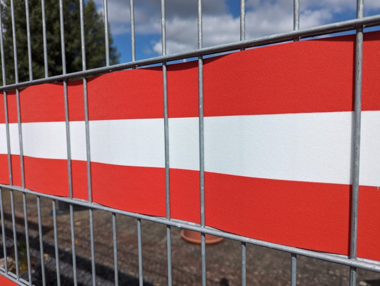 Bauzaun mit rot-weißem Warnband