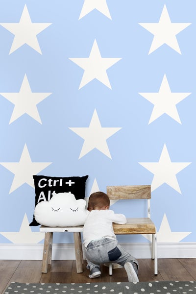 Kinderzimmer mit Sternentapete, Stuhl und Kissen