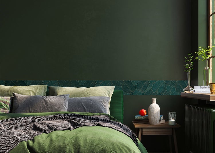 Tapetenbordüre mit Blattmuster als Wanddekoration in einem Schlafzimmer über dem Bett.