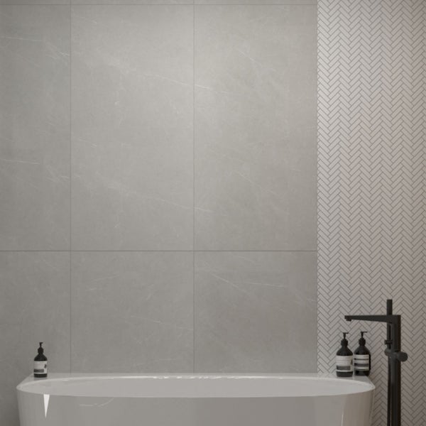 Modernes Badezimmer mit Badewanne, grauen Fliesen und Fischgrätmuster