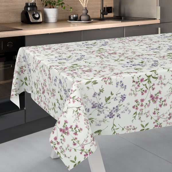 Rechteckige Tischdecke mit floralem Muster aus lila und rosa Blüten in einer modernen Küche mit dunklen Schränken und Holz-Arbeitsplatte.