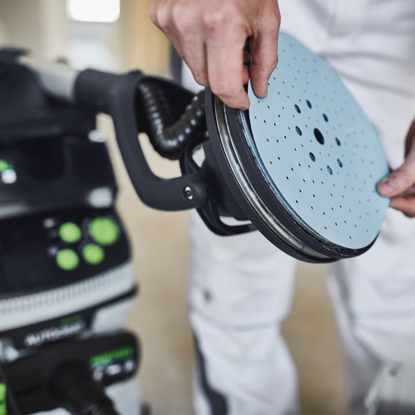 Eine Person befestigt Schleifpapier an einem Langhalsschleifer.