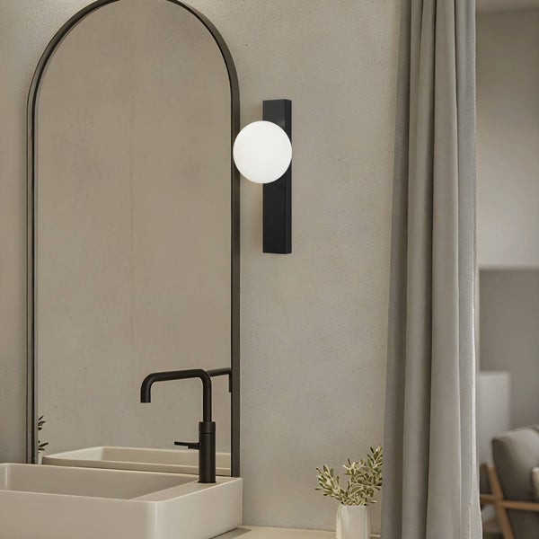 Badezimmeransicht mit Spiegel, Waschbecken und Wandleuchte