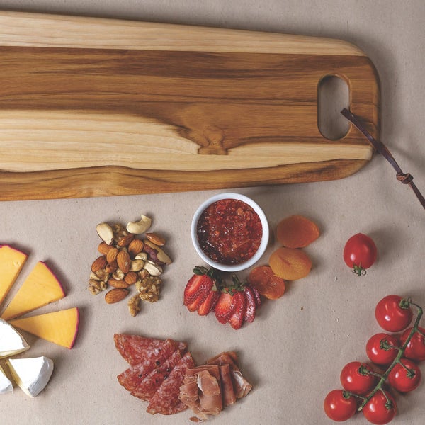 Holzschneidebrett mit Käse, Nüssen, Marmelade, Erdbeeren, Trockenfrüchten, Salami und Tomaten