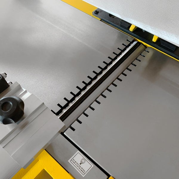 Detailansicht einer Hobelmaschine mit Einstellmechanismus und Sicherheitshinweis.