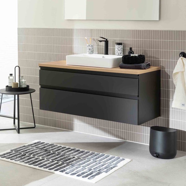 Badezimmer mit Waschtischunterschrank, Aufsatzwaschbecken und Badaccessoires.